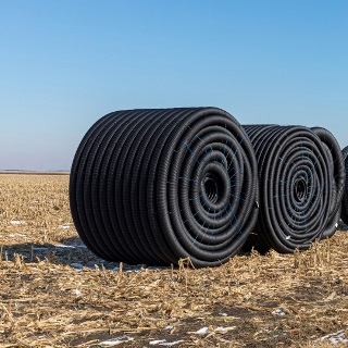 Rolls of tiling in empty field.